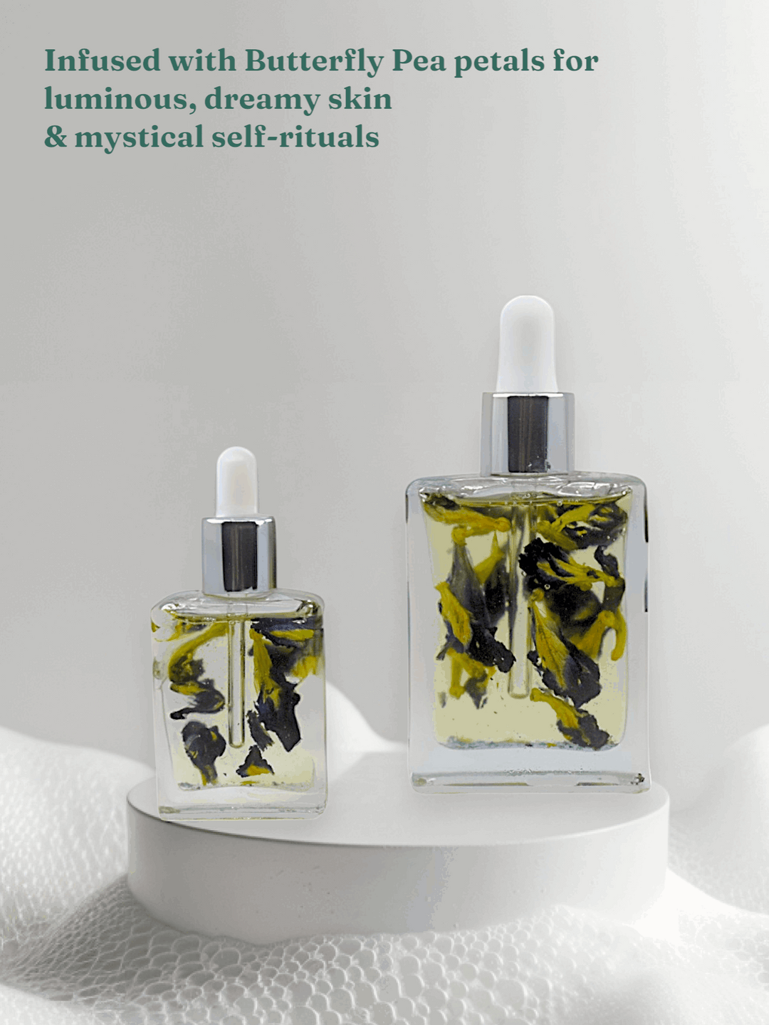 Bottle of Celestial Bloom Oil with butterfly pea flowers by Gaiaé. Botanical massage oil for glowing, soft skin.
